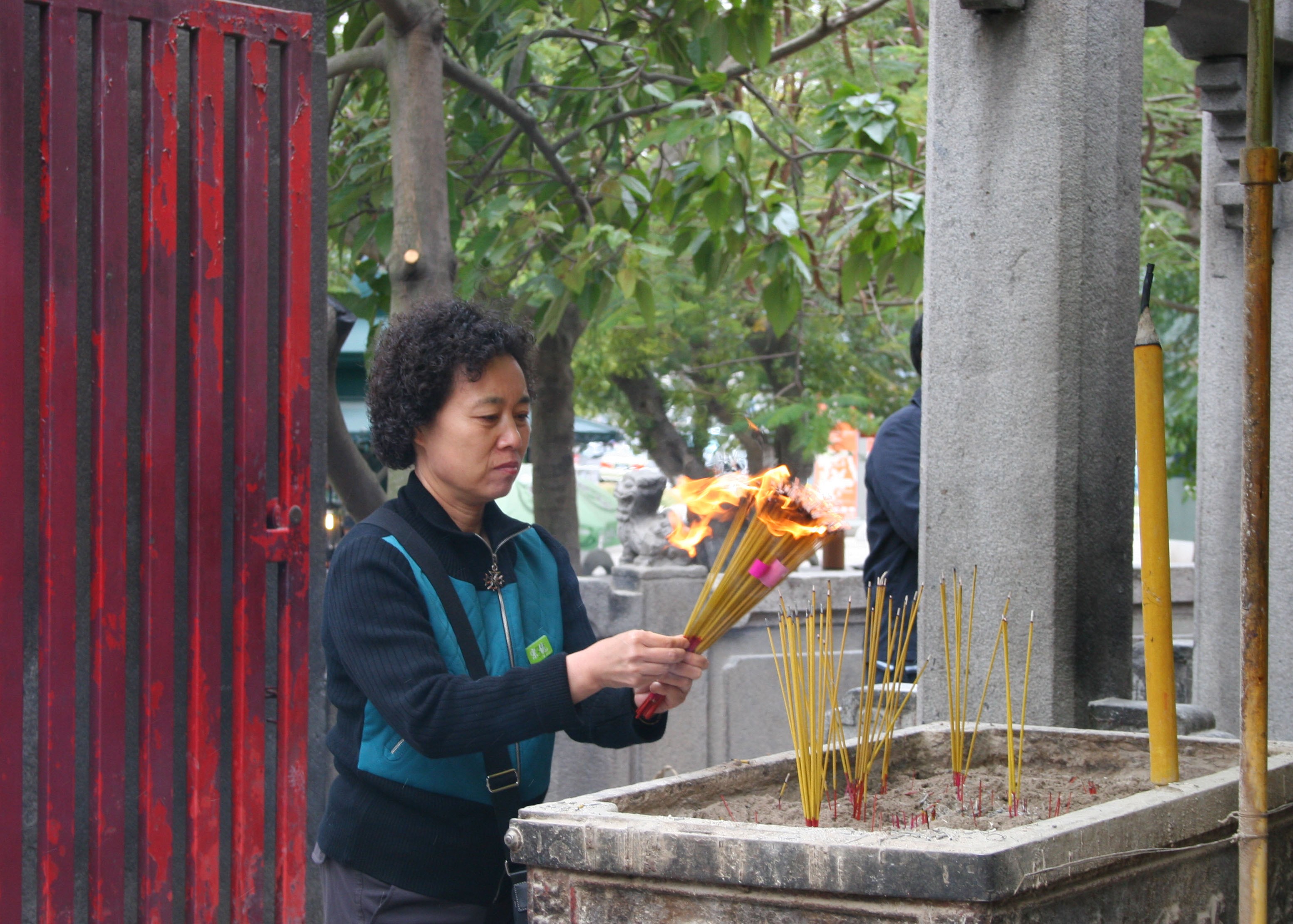 Woman lighting joss sticks at A-Ma Temple